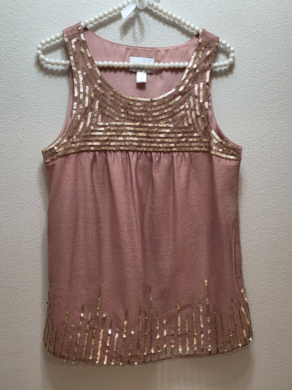 Mauve-pink sleeveless tank top featuring an embellished scoop neckline